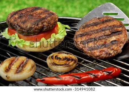 Spatula And Barbecue Burgers On The Hot Charcoal Grill. Cookout Concept. Good Snack For Summer Outdoor Party Or Picnic.Backyard Lawn In The Background.