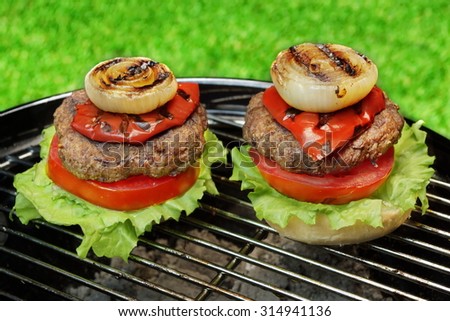 Barbecue Hamburgers On The Hot Charcoal Grill. Cookout Concept. Good Snack For Summer Outdoor Party Or Picnic.Backyard Lawn In The Background.