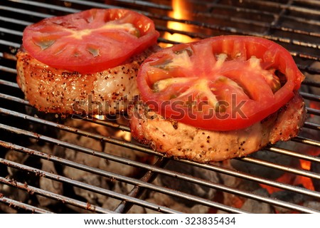 Pork Loin Pepper Steaks On The Hot BBQ Grill With Vibrant Flames In The Background, Close Up