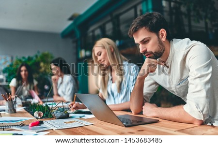 Group of young business people are working together in modern office. Creative people with laptop, tablet, smart phone, notebook. Successful hipster team in coworking. Freelancers. Сток-фото © 