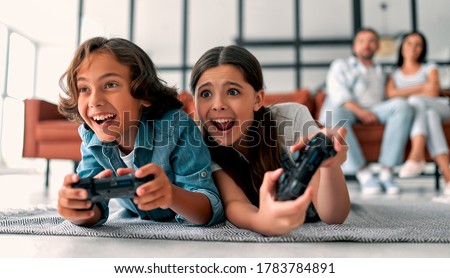 Similar – Image, Stock Photo Children playing video game in evening time