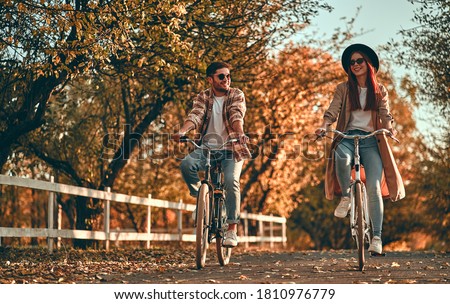 Young couple with bicycles in park in autumn time. 