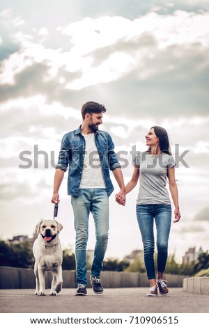 https://image.shutterstock.com/display_pic_with_logo/177219002/710906515/stock-photo-romantic-couple-is-on-a-walk-in-the-city-with-their-dog-labrador-beautiful-young-woman-and-710906515.jpg