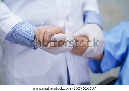 Doctor holding touching hands Asian senior or elderly old lady woman patient with love, care, helping, encourage and empathy at nursing hospital ward : healthy strong medical concept 