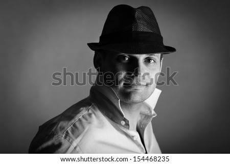Handsome smiling man in hat looking at camera black and white