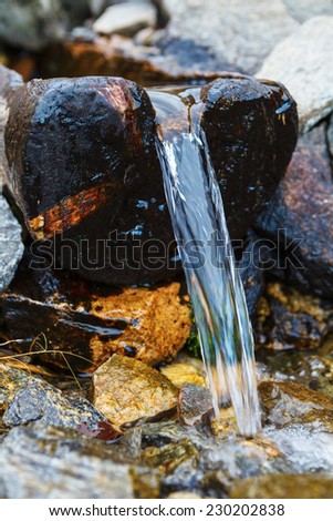 Water pouring out of a wooden trough