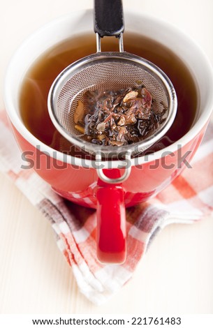 Natural tea  . Tea strainer in cup of herb tea