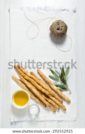 Italian food. space for writing text. colored tomatoes, bread sticks with sesame seeds, olive oil and olive leaf.