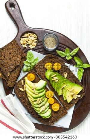 breakfast with sandwich with avocado on a cutting board on a white wooden background. healthy vegetarian breakfast