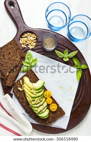 breakfast with sandwich with avocado on a cutting board on a white wooden background. healthy vegetarian breakfast