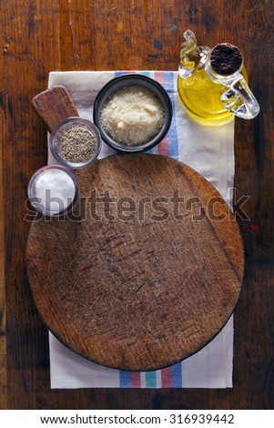 Chopping cutting board on wooden texture background . olive oil, parmesan cheese, pepper, salt. table serving in Italian. space for writing text. copyspace