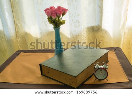 rose and old diary with clock.