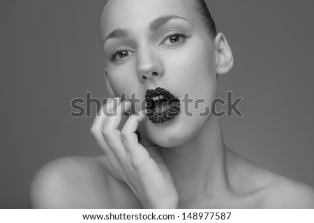 closeup beauty shot of beautiful model with black caviare lips. Makeup. open mouth. Perfect skin. BW. black and white