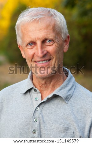 Closeup portrait of happy face of grey-haired old man. Outdoor