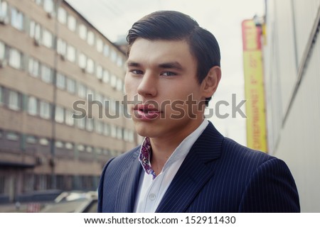 Young man in business suit posing on the street