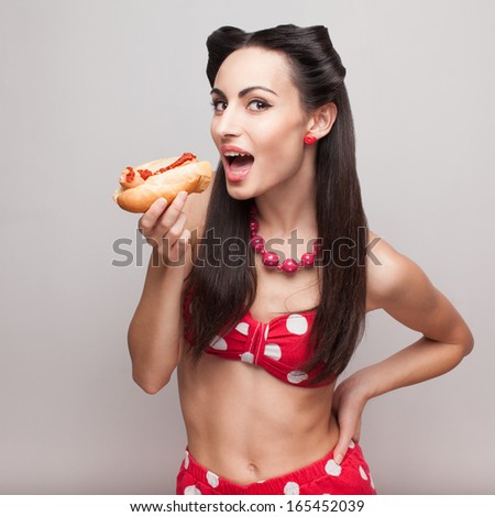 Sexy pinup model eating fast food sandwich