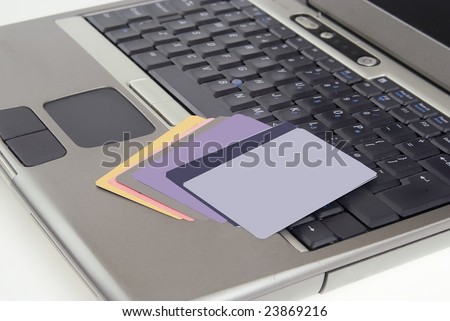 Personal identity fraud online, credit crdas on laptop against white backround