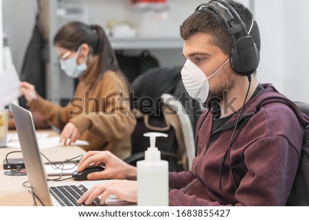 Coronavirus. Business workers working from home wearing protective mask. Small company in quarantine for coronavirus working from home with sanitizer gel. Small company concept.