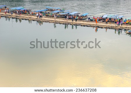 Bamboo bridge across the water with sky reflection