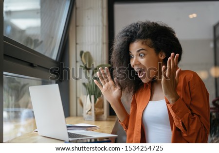 Excited African American woman win online lottery, celebration success. Happy emotional girl using laptop computer for online shopping, low price, hot deal, cash back on black Friday