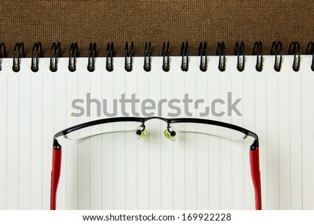 Note book with glasses on hard compressed paper board