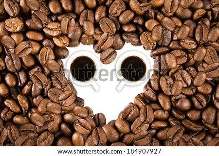 White heart shape space and cup round by roasted coffee beans