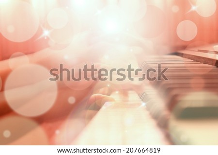 Vintage abstract hand playing piano with bokeh and flare light, blur background.