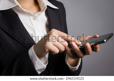 Close up businessman in black suit with hand touching smart phone.