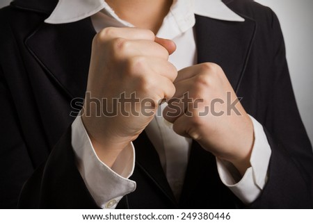 Abstract business woman in suit with her fists raised ready for a fight.