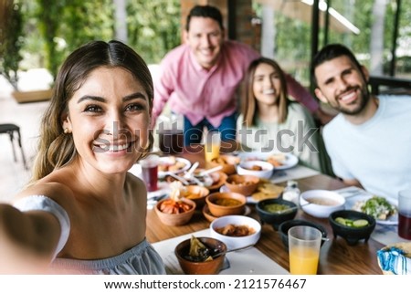 Mexican woman taking a photo selfie with group of latin friends and eating mexican food in restaurant terrace in Mexico Latin America Stok fotoğraf © 