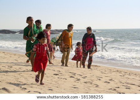 GOA, INDIA - JAN. 10,2014: Unknown family with the children stroll along the beach in Goa, India on JAN. 10, 2014