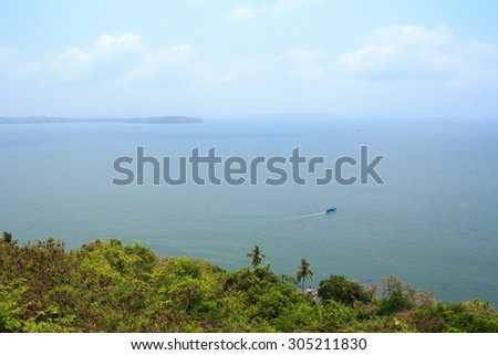 View of the Arabian Sea from the walls of the fort Aguada, Goa, India. The boat is to sail to the open sea. From the walls of the Portuguese fort Aguada open splendid views.