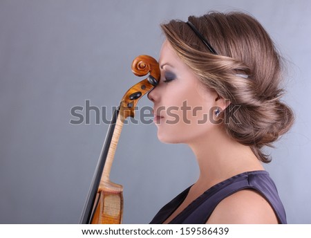 beautiful blue-eyed girl in a dark blue evening dress holding a violin handmade portrait on gray background