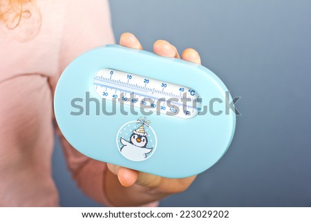 young pregnant woman measures the temperature in the room. Children\'s room thermometer