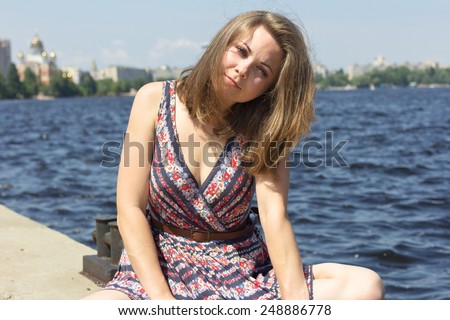 Pretty blue-eyed girl enjoying the sun and the good weather near the water.beautiful smiling girl relaxing on nature. Portrait outdoors. Face of a beautiful young girl