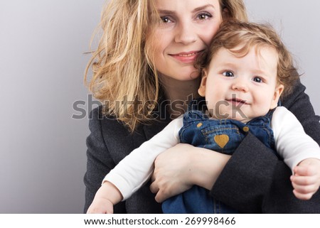young mother with a little boy in her arms. Portrait of mother and son. Beautiful blonde. pectoral baby. happy family