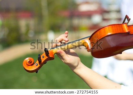 Girl playing on the violin outdoors. Musician for the wedding.Violin under the open sky