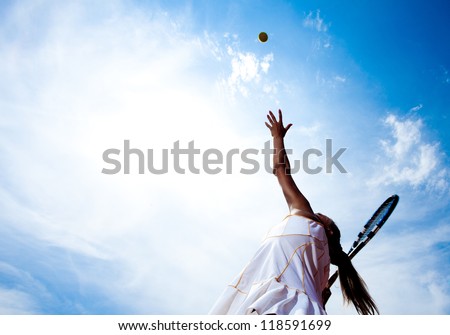 Tennis woman in a white tennis dress developing ball service