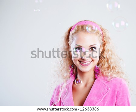 Young woman in pink clothes with soap bubbles