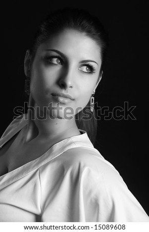 A young beautiful girl is dressed in white clothes at black background