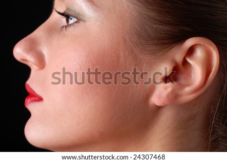 profile of a beautiful young woman at black background