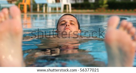 young man floating in the swimming pool