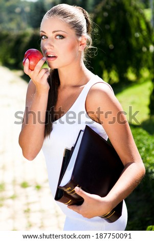 Young beautiful woman with apple and book