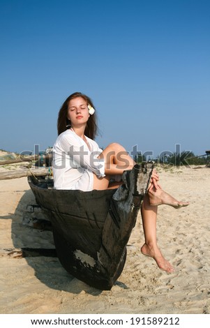 Young woman sitting in  black wooden boat