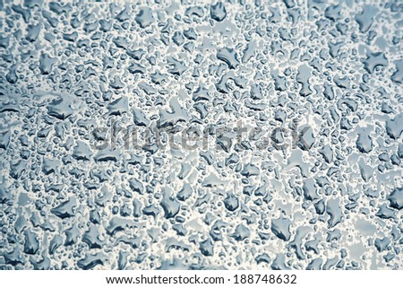 Water drops on metal background with reflection blurred on the edges. Image processing with color filter effect