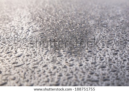Water drops on metal background with reflection blurred on the edges
