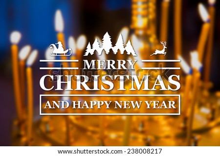 Merry Christmas and New Year greeting card on blurred glowing yellow church candles on background