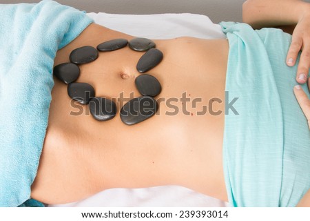 black hot stones therapy on the belly