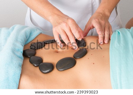 Massage with hot stone on belly