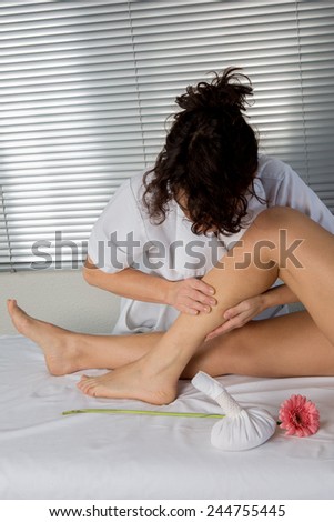Physiotherapist massaging the calves of a woman